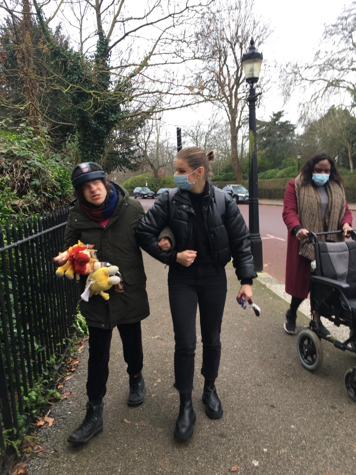 Ellie and support worker walking on the pavement.